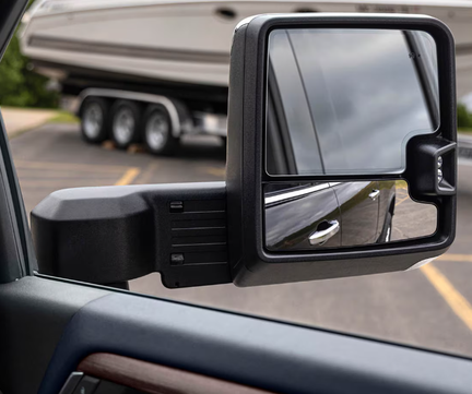 Chevrolet Silverado HD extended trailering mirror with a boat trailer behind the truck