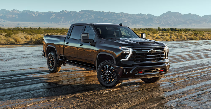 Black Chevrolet Silverado HD Stars and Steel Special Edition driving through shallow water on a desert flat