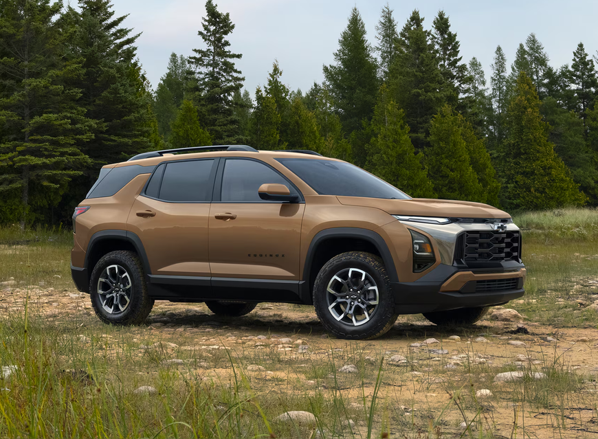 Autumn Harvest Metallic 2027 Chevrolet Equinox ACTIV parked in a clearing in front of pine trees