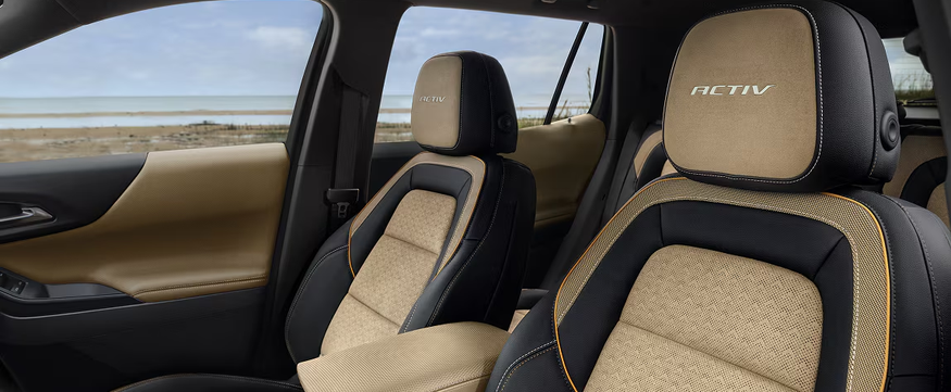 Tan and black front seats with ACTIV embroidery inside a Chevrolet Equinox