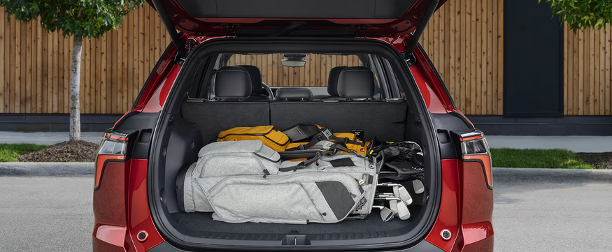 Red Chevrolet Equinox with its liftgate open and bags in the cargo area