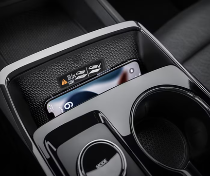 Phone resting on the Chevrolet Equinox wireless charging pad beside the cupholders