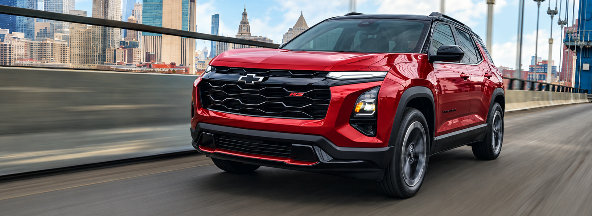 Red 2027 Chevrolet Equinox RS driving across a city bridge