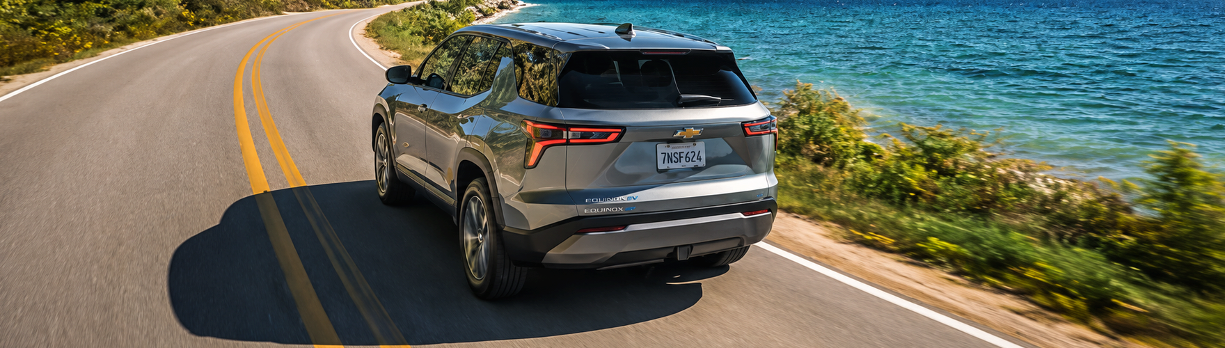 Silver Chevrolet Equinox driving along a coastal road
