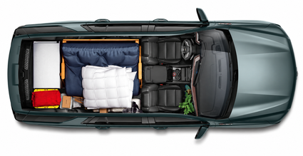 Overhead cutaway of a Chevrolet Tahoe with the rear rows folded, packed with boxes and bedding