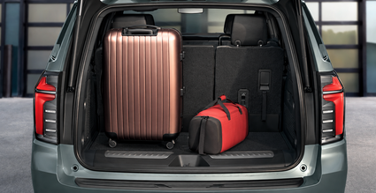 Open Chevrolet Tahoe liftgate showing a suitcase and duffel bag in the cargo area