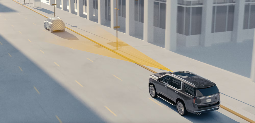 Chevrolet Tahoe keeping a highlighted following distance behind a vehicle on a city street
