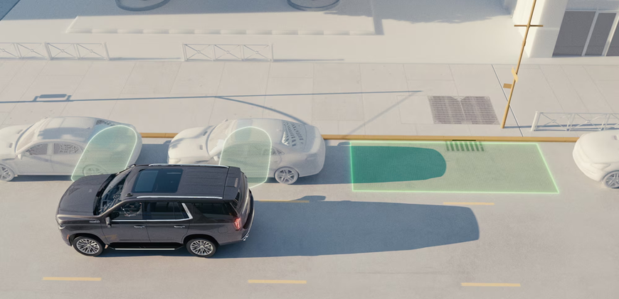 Chevrolet Tahoe parking itself into a highlighted space between parked cars