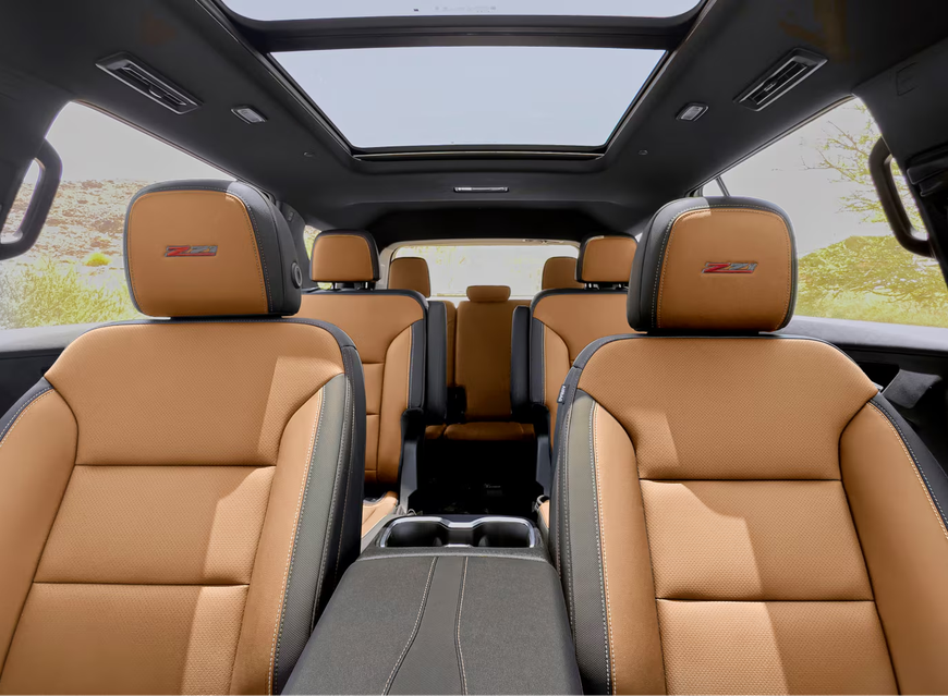 Three rows of tan seats inside a Chevrolet Traverse under the panoramic sunroof