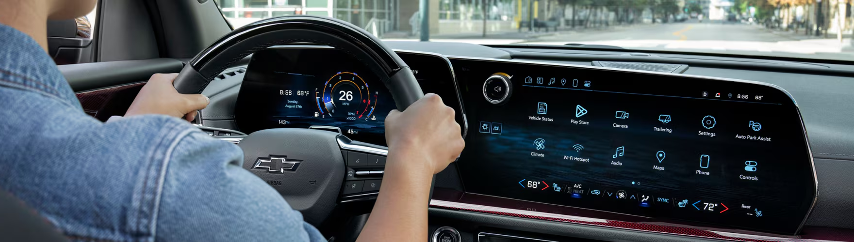 Driver's hands on the Chevrolet Traverse steering wheel in front of the digital displays
