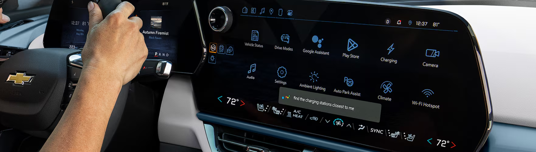 Driver's hand on the Chevrolet Traverse center display showing Google built-in apps