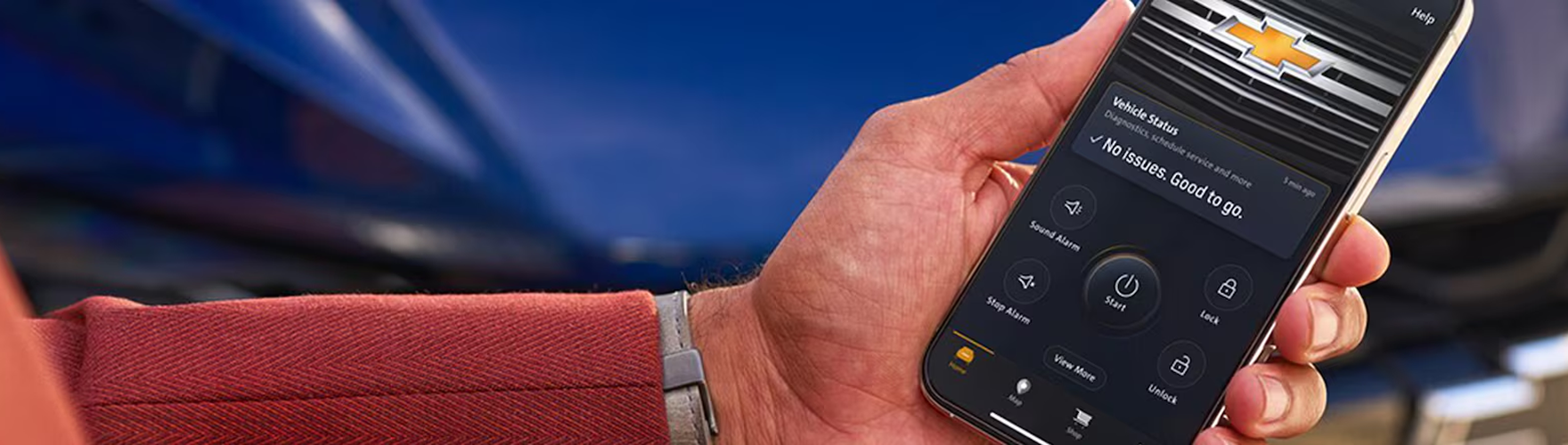 Hand holding a phone with the Chevrolet app open