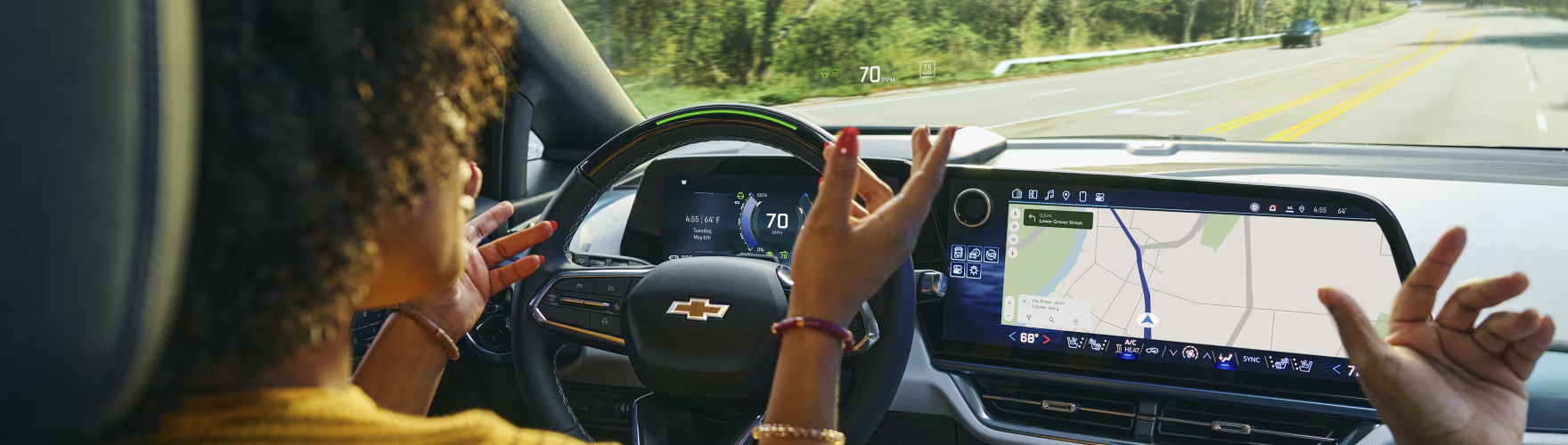 Driver relaxing with hands raised while Super Cruise steers the Chevrolet Traverse
