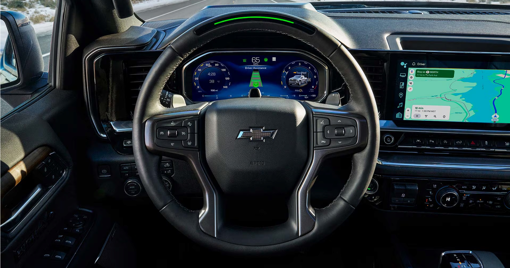 Steering wheel and digital driver display with the Super Cruise light bar glowing green