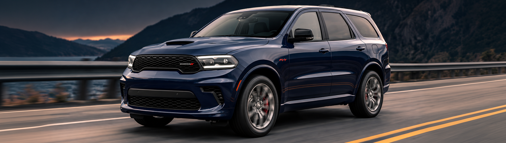 Dark blue Dodge Durango driving along a coastal highway at dusk