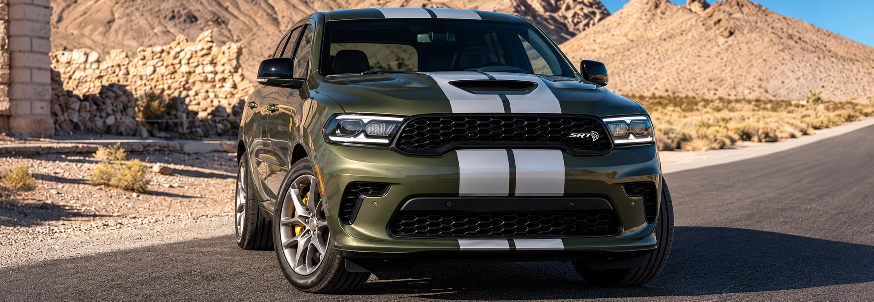 Olive green Dodge Durango SRT with silver racing stripes on a desert road