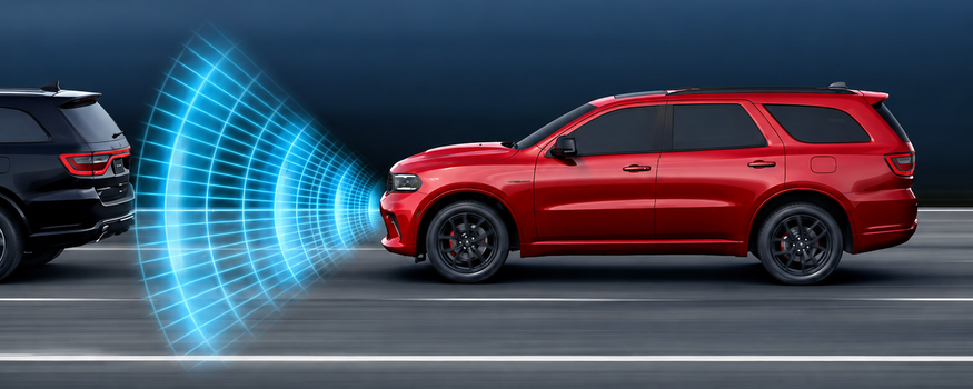 Red Dodge Durango with forward collision sensor waves approaching a black vehicle