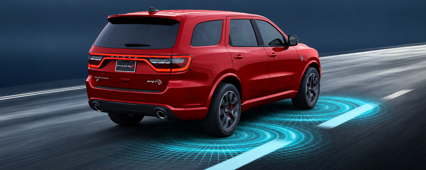 Red Dodge Durango with lane guidance graphics on the road