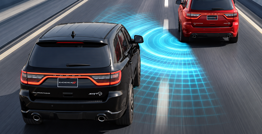 Black Dodge Durango with blind spot sensor waves detecting a red vehicle behind it