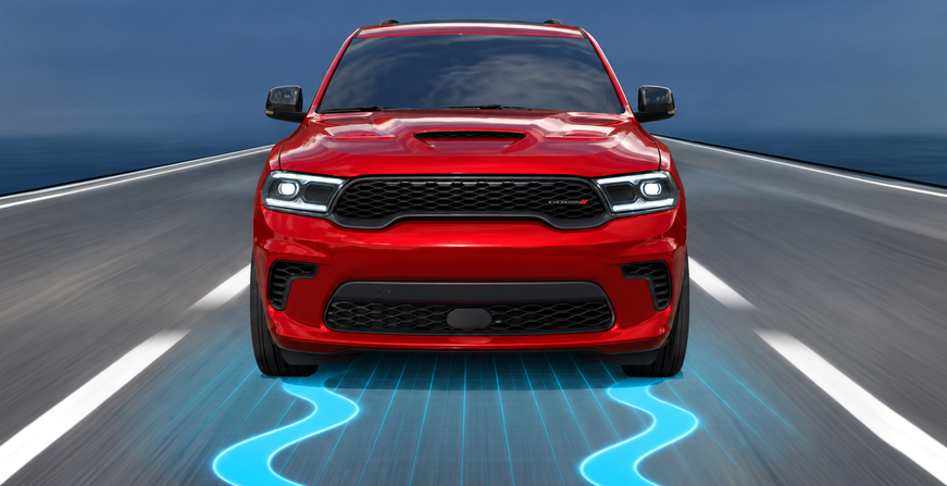 Red Dodge Durango with stability control graphics on a curving road
