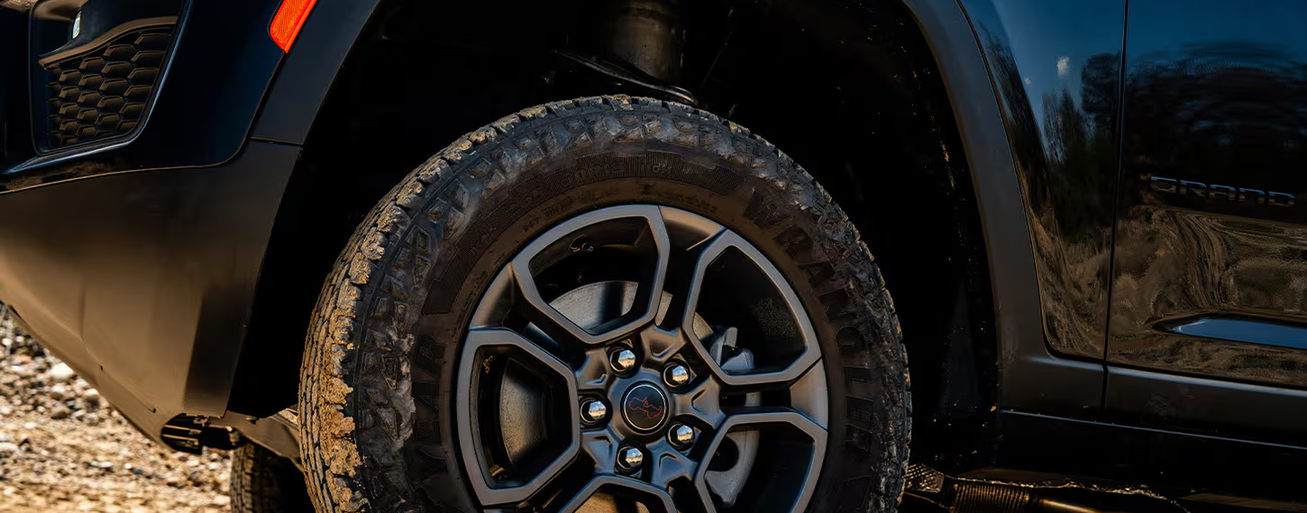Close-up of a Grand Cherokee Trailhawk all-terrain tire on a gravel trail