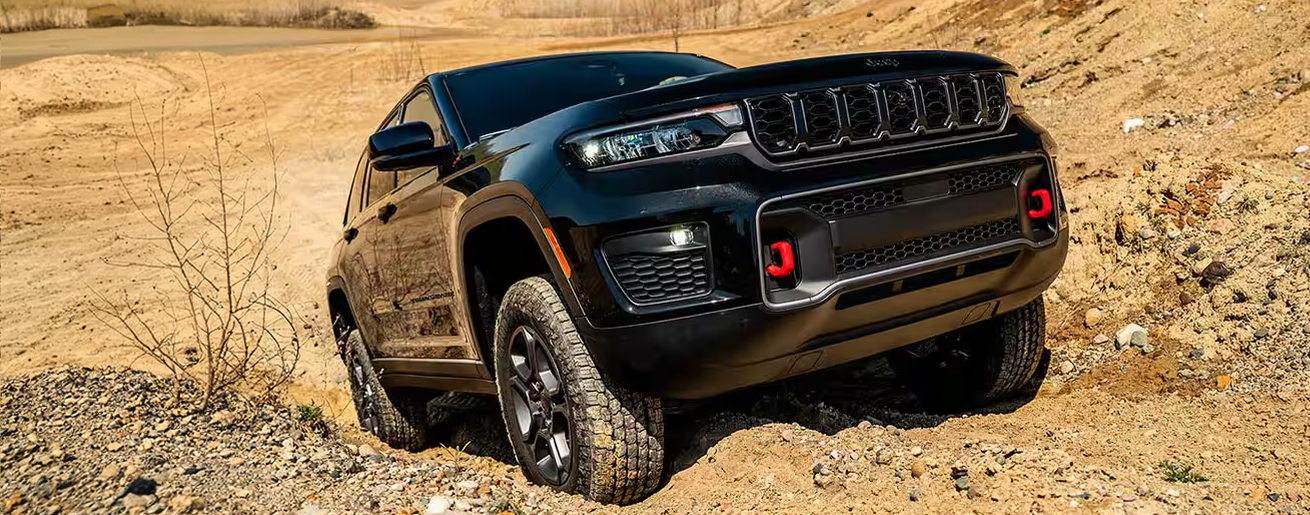 Black Grand Cherokee Trailhawk climbing over sandy terrain