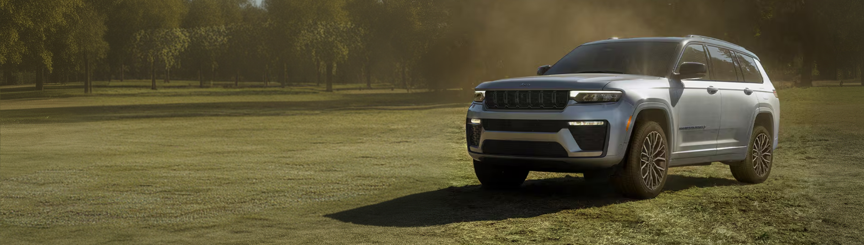 Silver Grand Cherokee driving across a grassy field