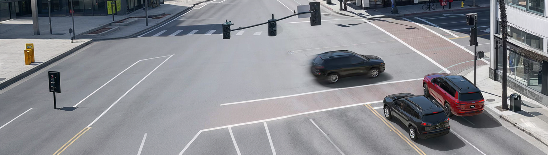 Aerial view of Grand Cherokees crossing a four-way intersection