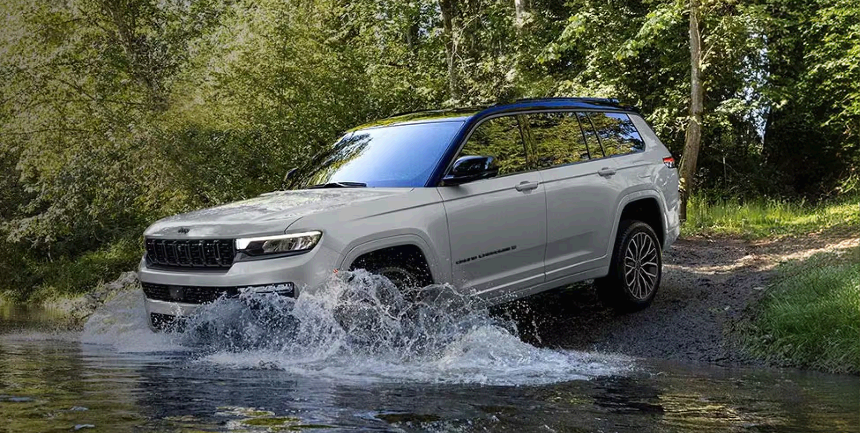 White Grand Cherokee splashing through a forest stream
