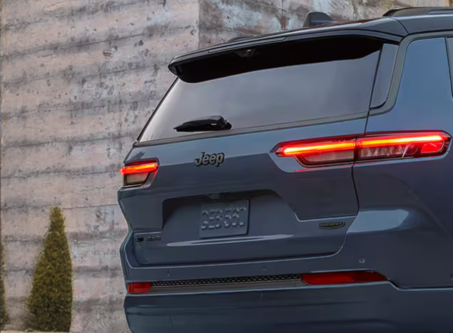Rear of a blue Grand Cherokee with its full-width LED taillamps lit