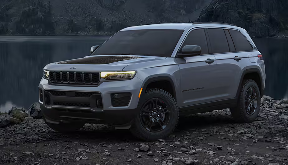 Silver 2027 Jeep Grand Cherokee Upland on a rocky lakeshore at dusk
