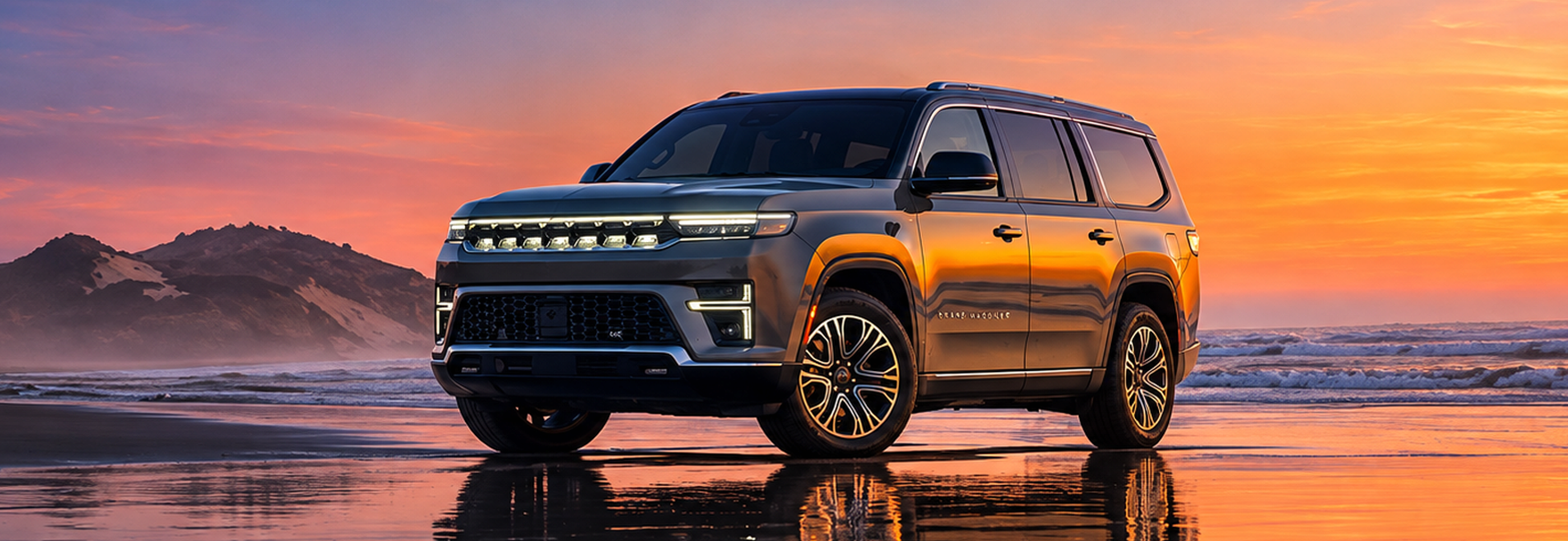 Bronze 2027 Jeep Grand Wagoneer parked on a beach at sunset with its lights on